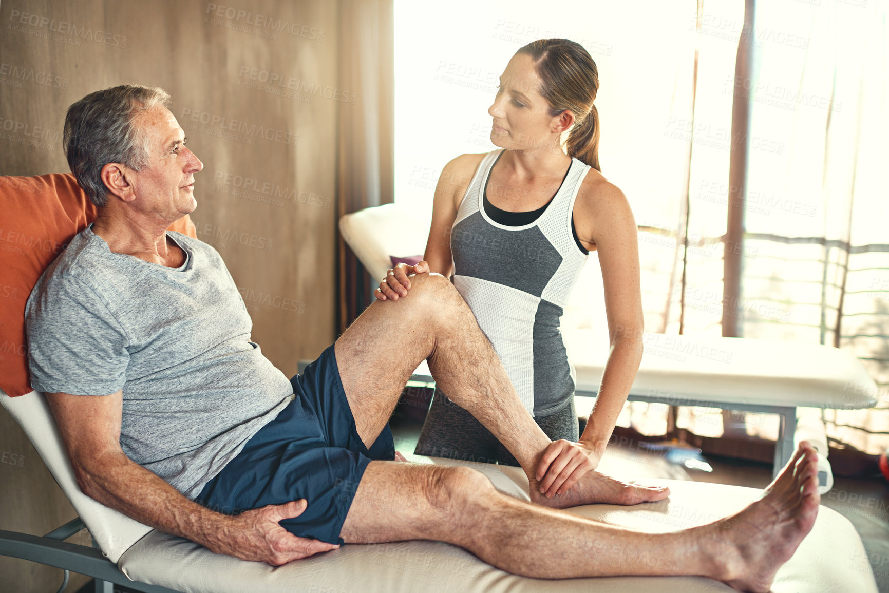 Buy stock photo Senior man, female physiotherapist and medical in retirement home for health, support and patient with osteoporosis. Male person, physiotherapy and consulting on bed for wellness, help and arthritis
