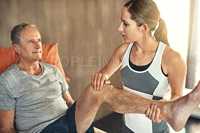 Buy stock photo Shot of a senior man being treated by a physiotherapist