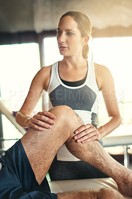 Buy stock photo Shot of a man being treated by a physiotherapist