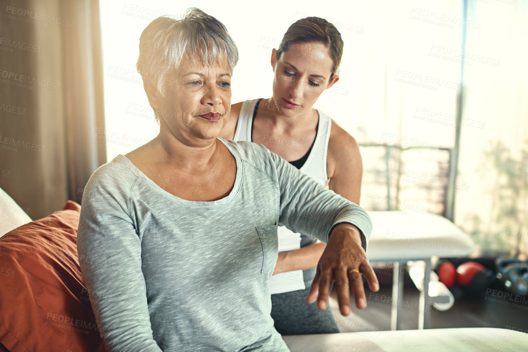 Buy stock photo Shot of a senior woman being treated by a physiotherapist