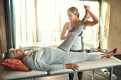 Buy stock photo Shot of a senior woman being treated by a physiotherapist