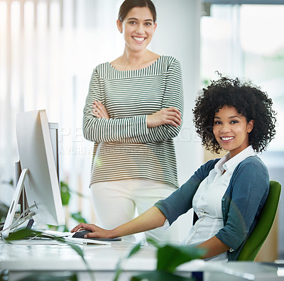 Buy stock photo Portrait of two smiling young designers working on a computer in a modern office