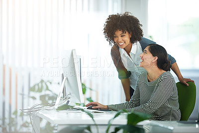 Buy stock photo Shot of two smiling young designers working on a computer in a modern office