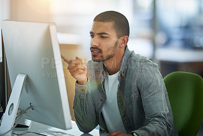 Buy stock photo Shot of a young designer deep in thought while working on a computer in a modern office
