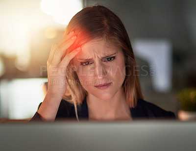 Buy stock photo Shot of a young businesswoman with a headache working at her computer in the office