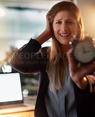Buy stock photo Portrait of a frantic young businesswoman holding up an alarm clock while standing in the office