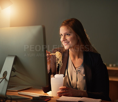 Buy stock photo Shot of a young designer eating takeaways while working late in the office