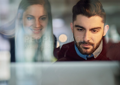 Buy stock photo Shot of two young entrepreneurs working together on a laptop in an office