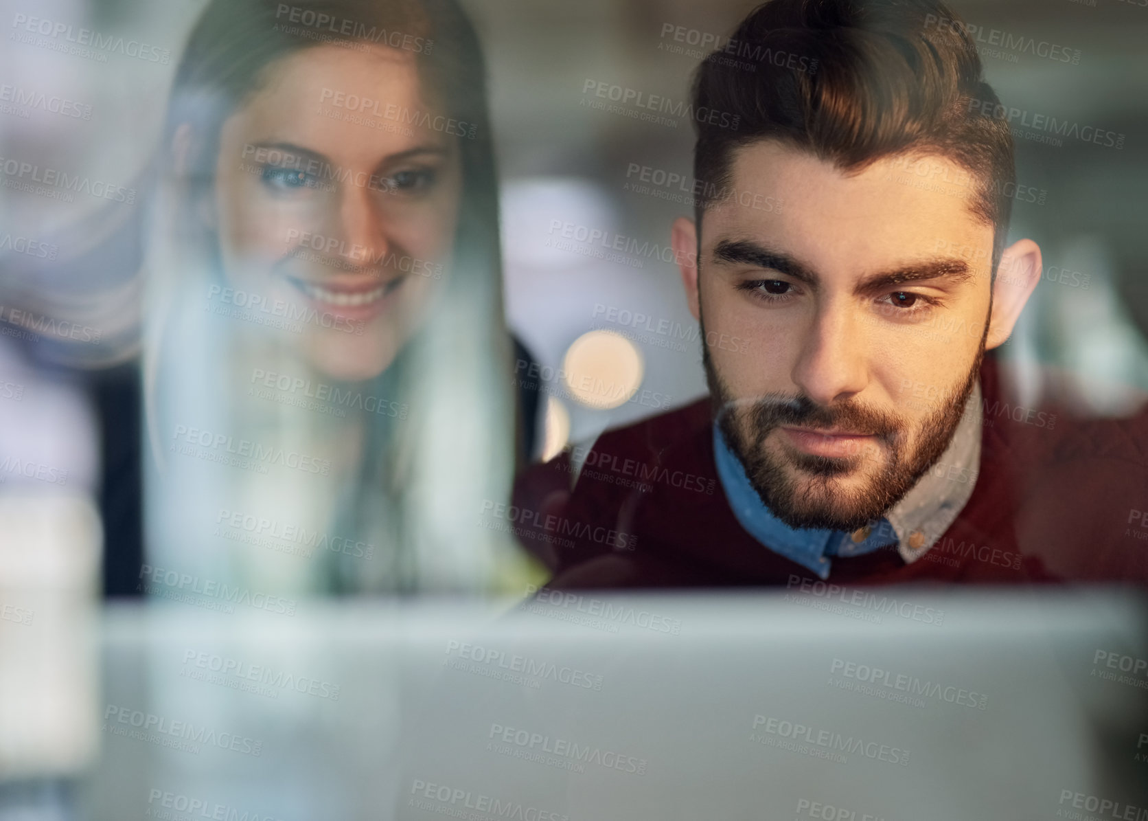 Buy stock photo Shot of two young entrepreneurs working together on a laptop in an office