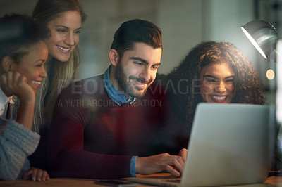Buy stock photo Shot of a group of young entrepreneurs working late on a laptop in an office