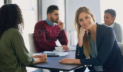 Buy stock photo Portrait of a young entrepreneur sitting in an office with her colleagues in the background