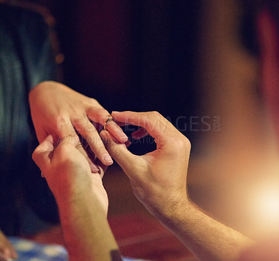 Buy stock photo Cropped shot of a man putting an engagement ring onto his fiancee’s finger