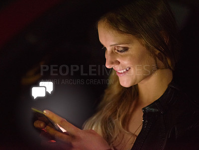 Buy stock photo Shot of a young woman getting a notification on her smart phone at night
