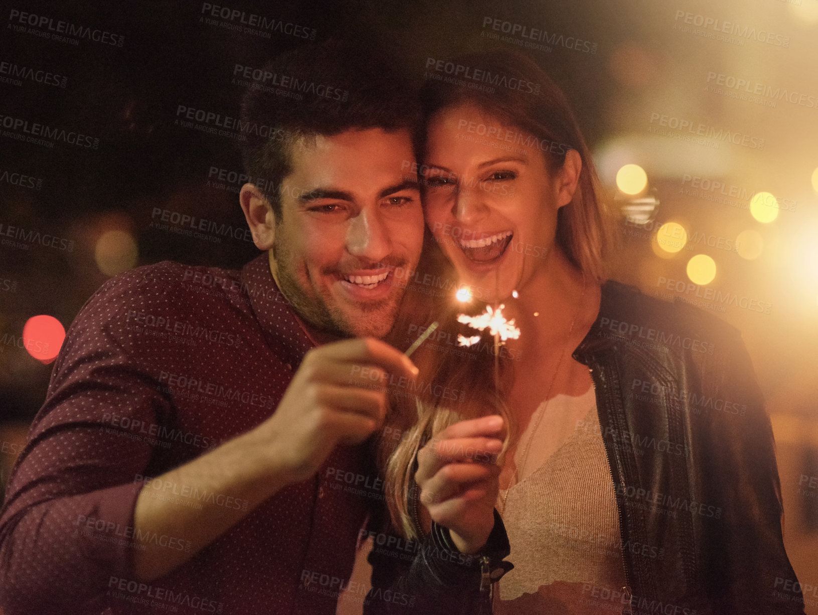 Buy stock photo Excited, couple and sparklers at night for party, celebration and event together outdoor in city with bokeh light. Happy, man and woman with fireworks on holiday, romantic date or laugh on vacation