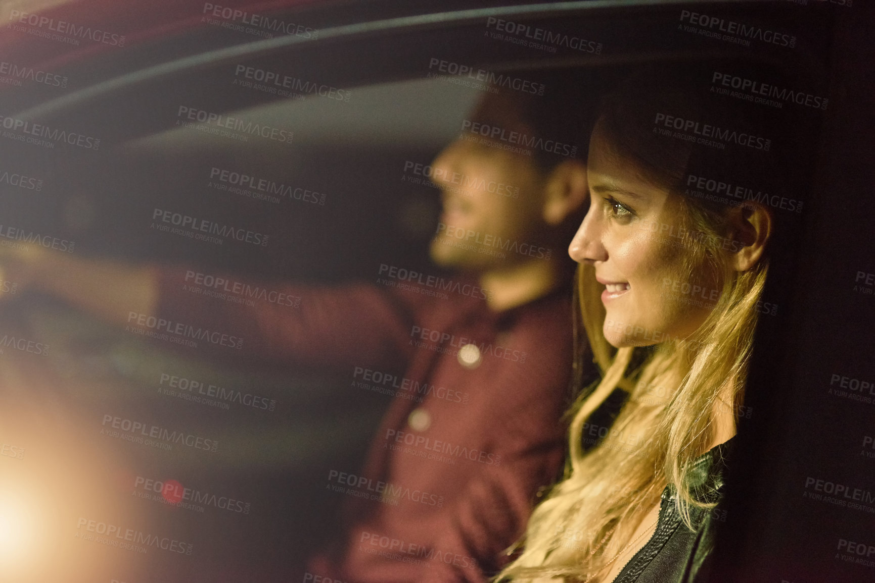 Buy stock photo Shot of a young couple traveling in a car together at night