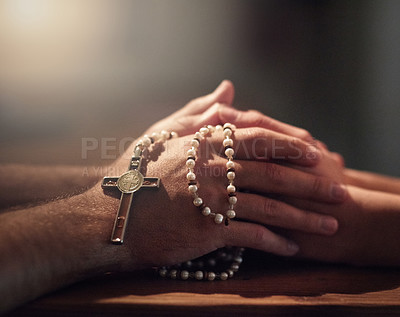 Buy stock photo Cropped shot of two people praying while holding a rosary