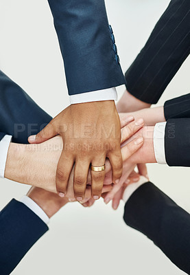 Buy stock photo Closeup shot of a group of businesspeople standing in a huddle with their hands stacked together