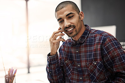 Buy stock photo Shot of a young entrepreneur talking on a cellphone in an office