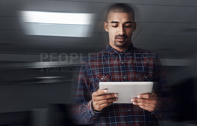 Buy stock photo Shot of a young entrepreneur working on a digital tablet in an office