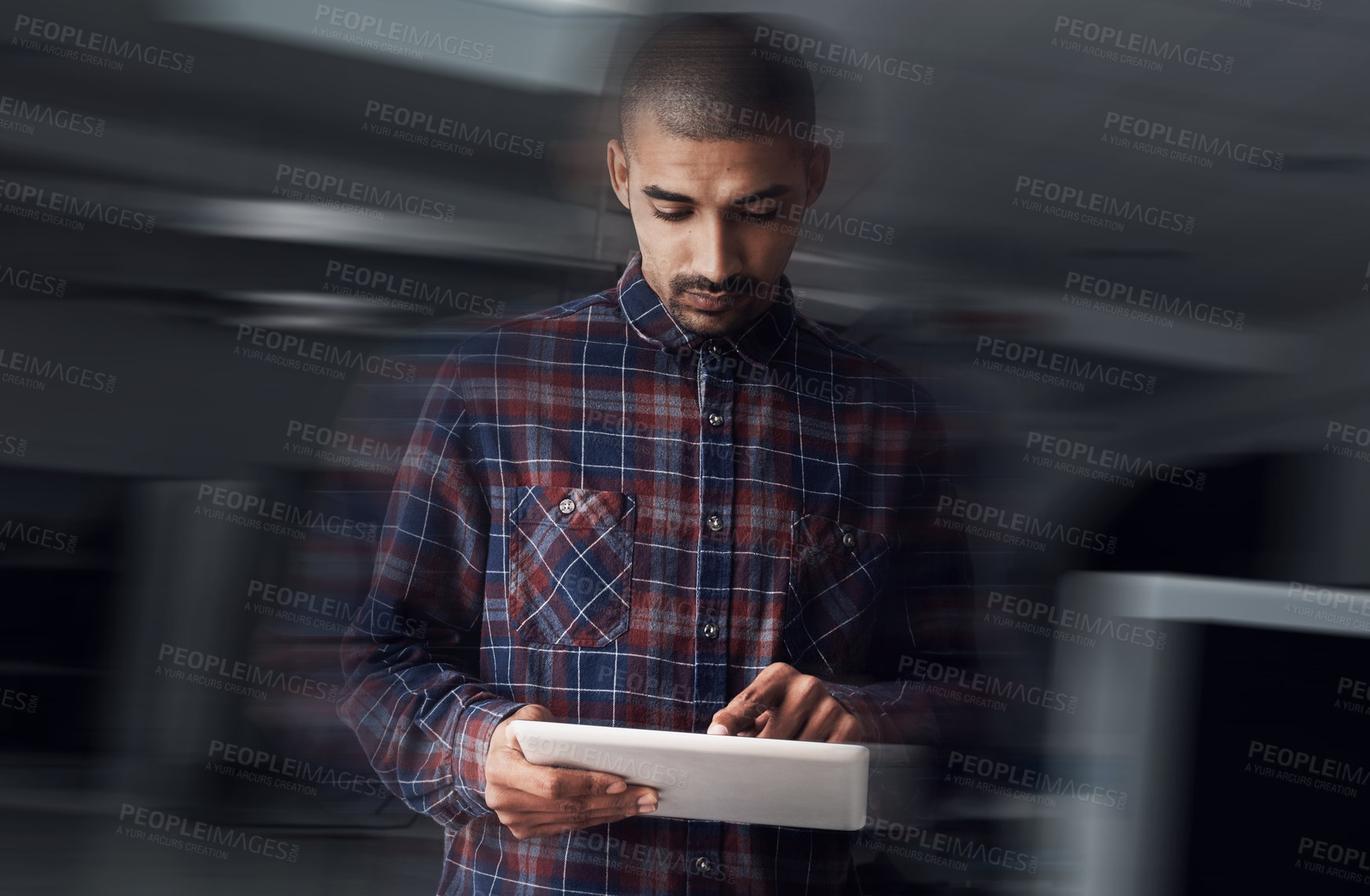 Buy stock photo Shot of a young entrepreneur working on a digital tablet in an office