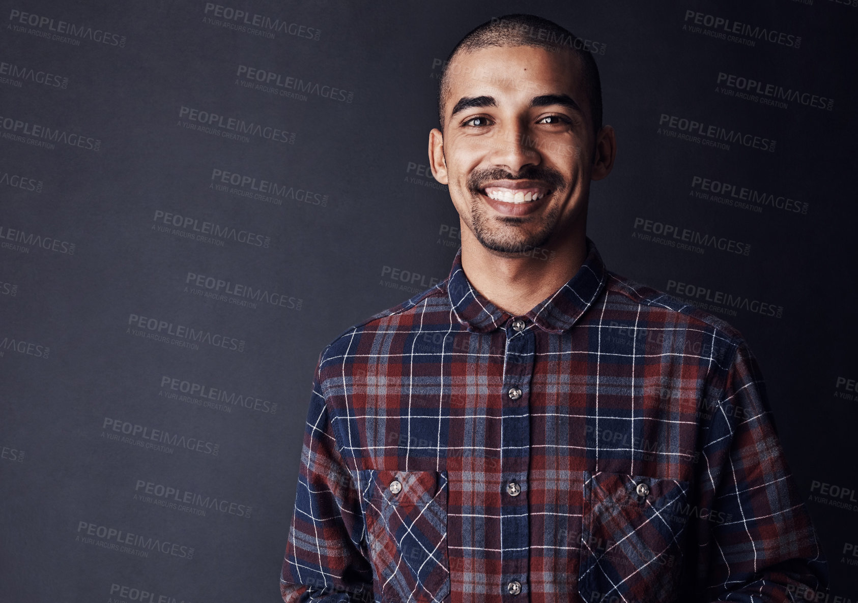 Buy stock photo Studio shot of a young man standing against a dark background