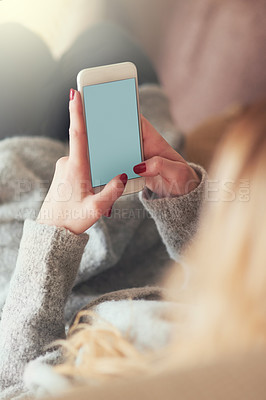 Buy stock photo Cropped shot of a young woman texting on her cellphone at home