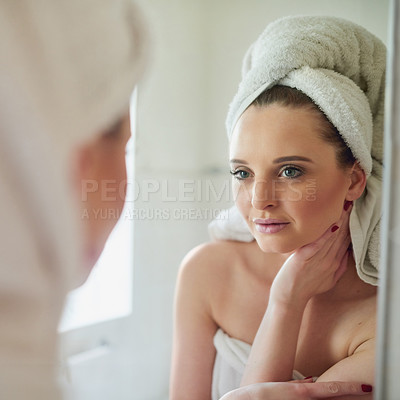Buy stock photo Shot of an attractive young woman looking at herself in the bathroom mirror