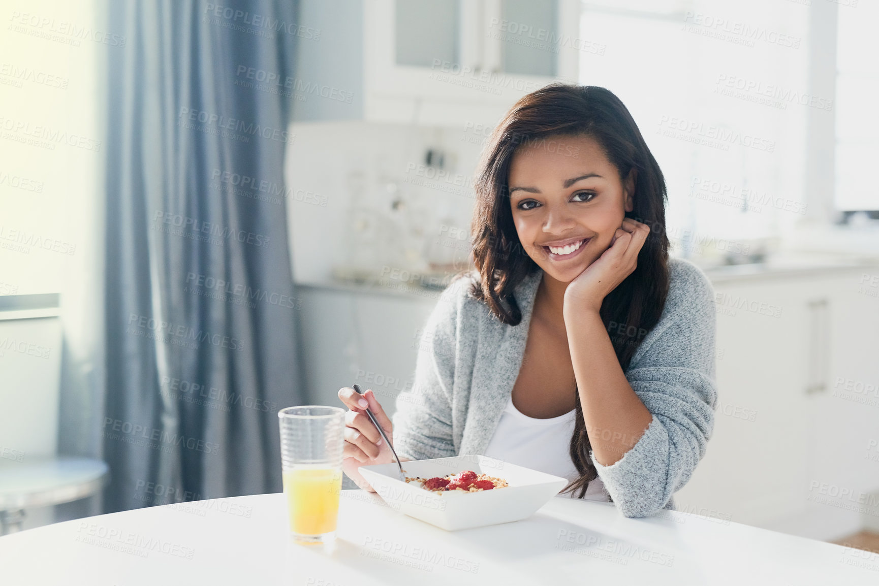 Buy stock photo Portrait of a happy young woman enjoying a healthy breakfast at home