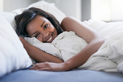 Buy stock photo Shot of a happy young woman waking up in her bed at home