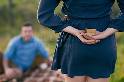Buy stock photo Rear view shot of a woman about to propose to her boyfriend with an engagement ring in a box