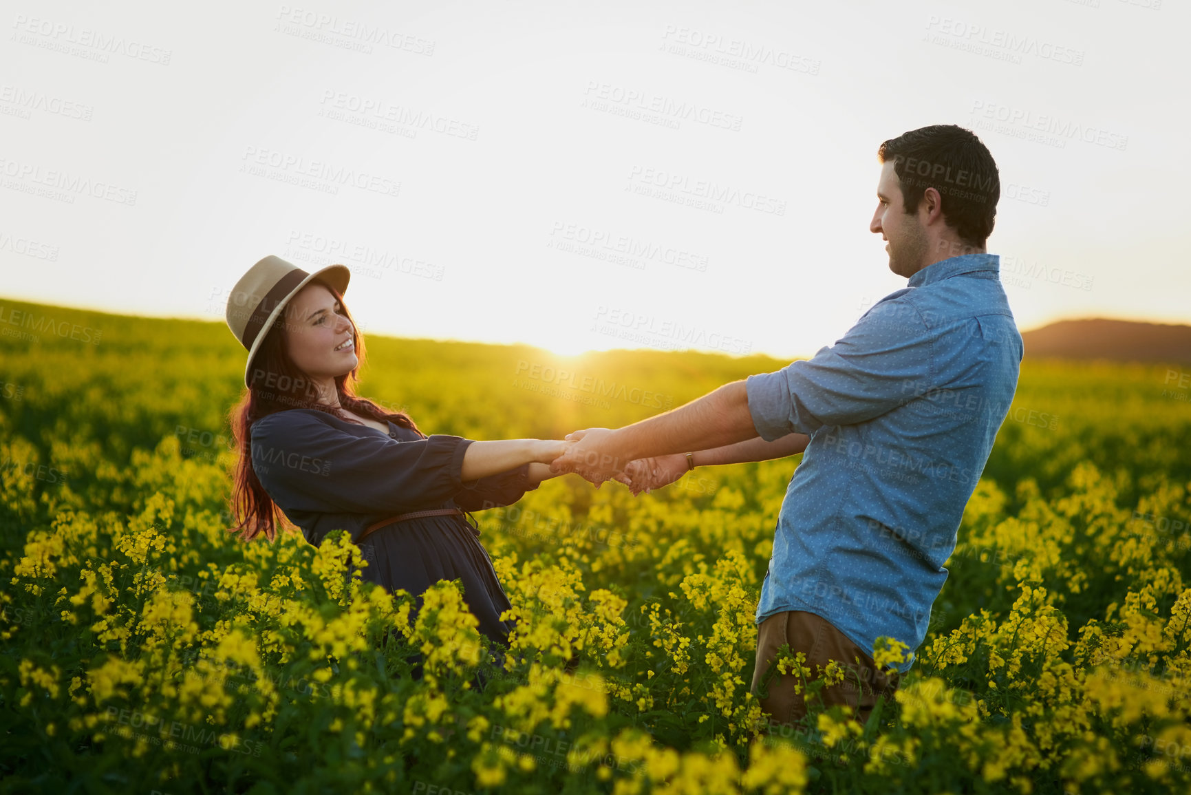 Buy stock photo Couple, dance and sunset with field of flowers with care, love and bonding for memory on travel in countryside. Man, woman and vacation with holding hands, connection and floral plants in spring