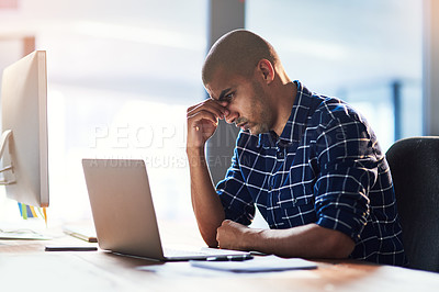 Buy stock photo Cropped shot of a young designer looking stressed out while working at his office desk