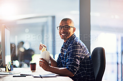 Buy stock photo Portrait of a young designer eating takeaways while working at his office desk