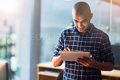 Buy stock photo Cropped shot of a young designer working on a digital tablet in an office