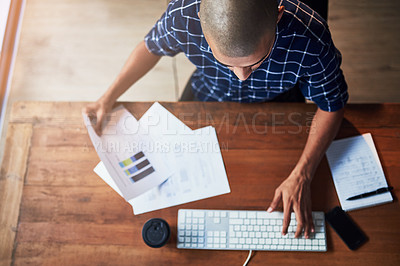 Buy stock photo High angle shot of a young designer working at his office desk