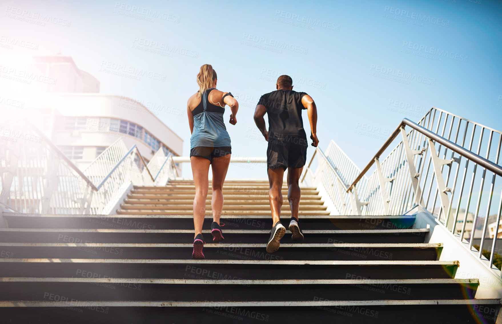 Buy stock photo Rearview shot of two young people jogging up an outdoor flight of stairs