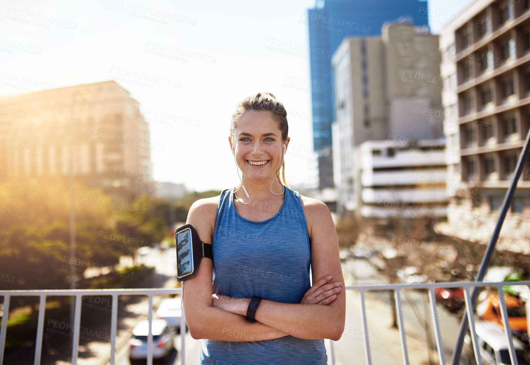 Buy stock photo Portrait of a sporty young woman standing with her arms folded outdoors