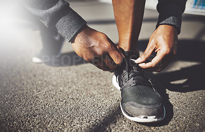 Buy stock photo Shot of a sporty man tying his laces before a run