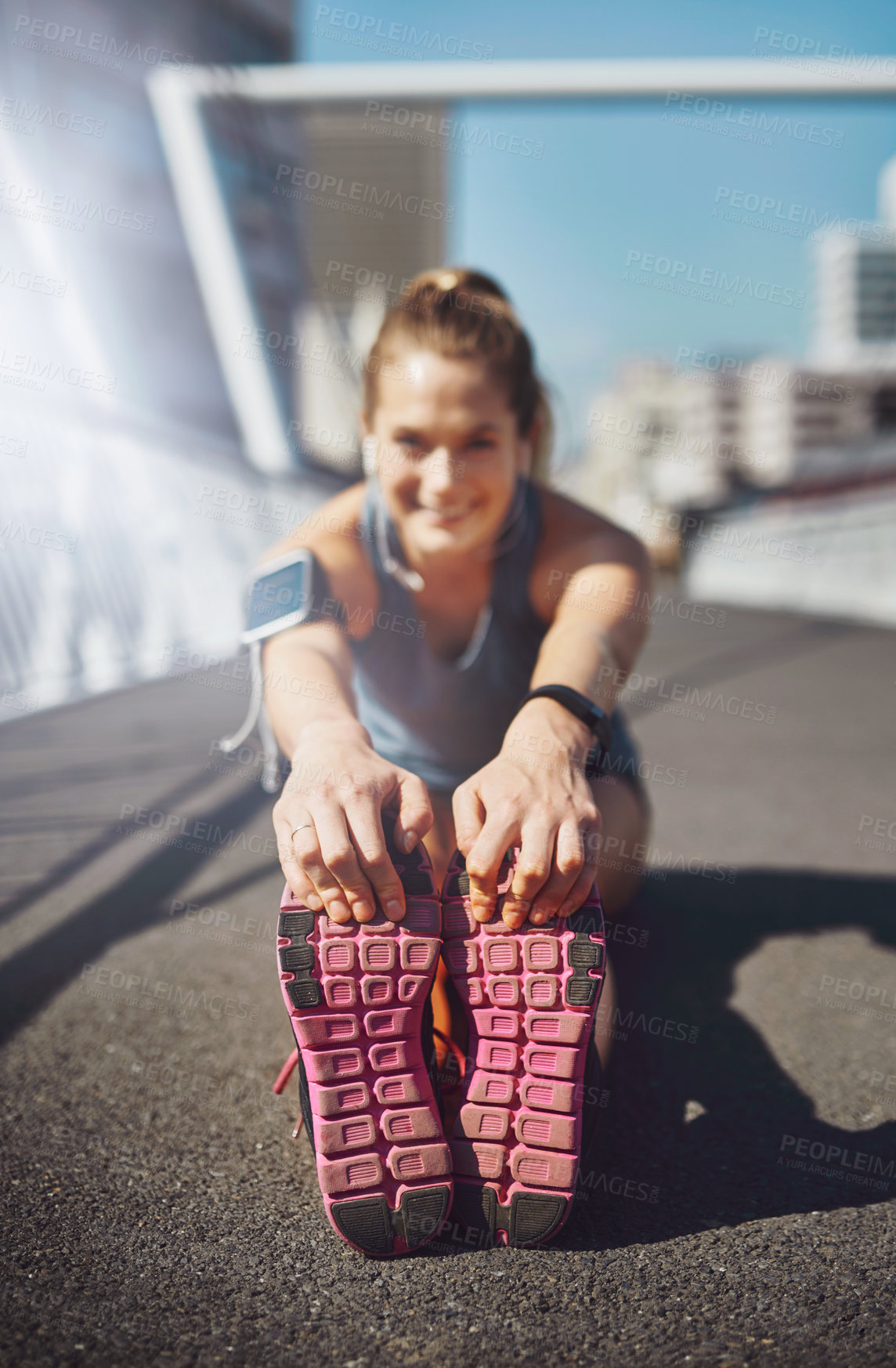 Buy stock photo Happy woman, legs and stretching with earphones in city for fitness, exercise or workout preparation on bridge. Active, female person or runner with smile for body or foot warm up in an urban town