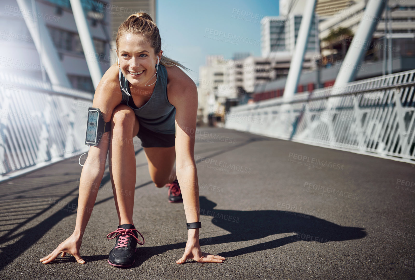 Buy stock photo Shot of a sporty young woman getting set for a run