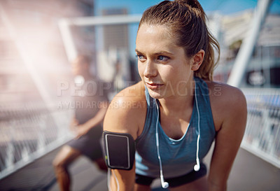 Buy stock photo Shot of two sporty young people standing on a bridge during their workout