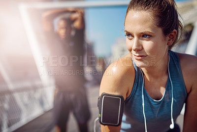Buy stock photo Shot of two sporty young people standing on a bridge during their workout