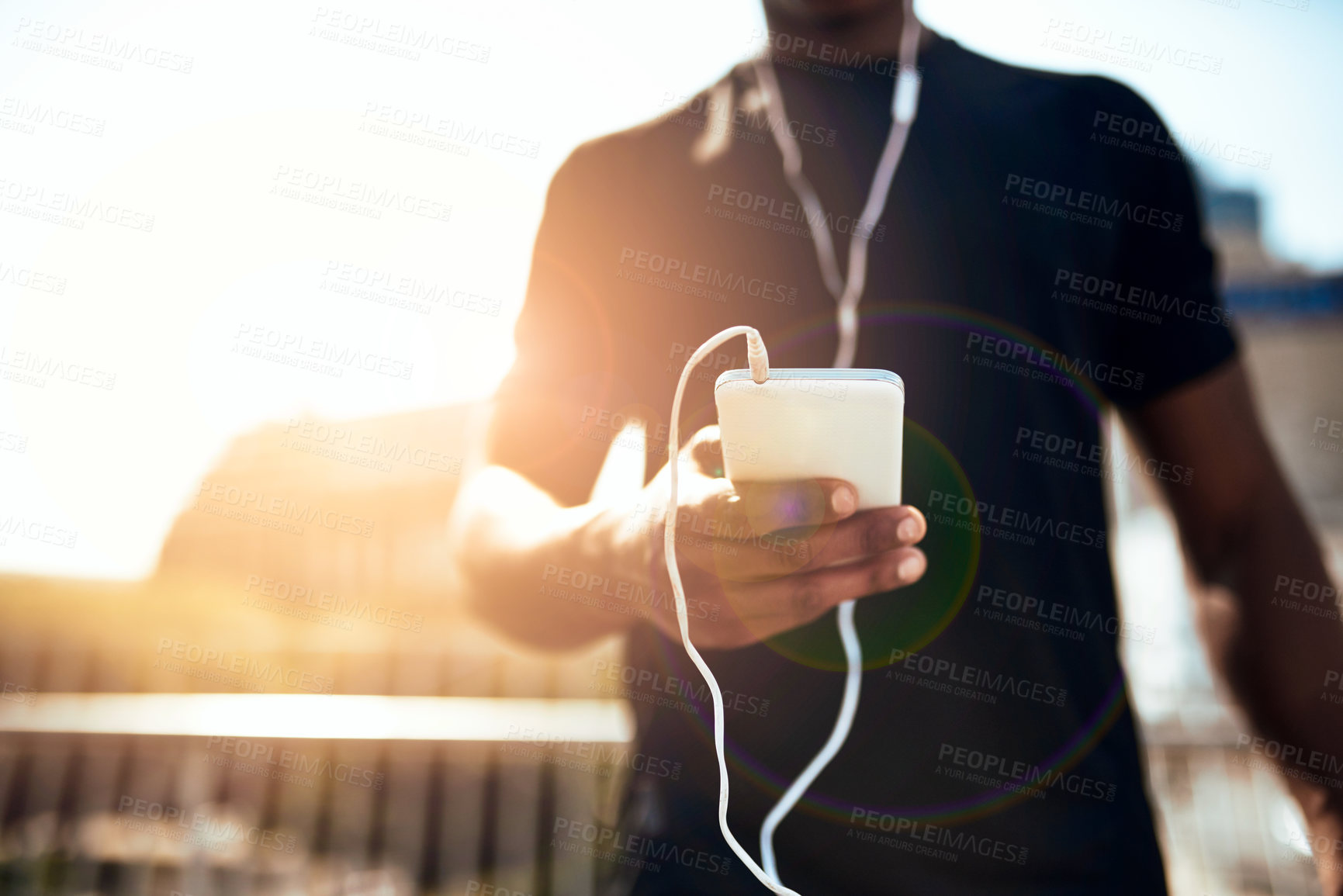 Buy stock photo Shot of a sporty young man getting his playlist ready for a run