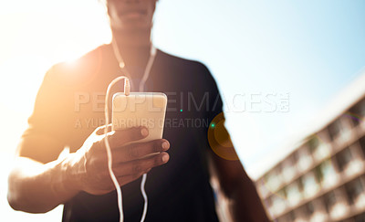 Buy stock photo Shot of a sporty young man getting his playlist ready for a run