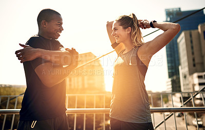 Buy stock photo Shot of two sporty young people warming up before a run