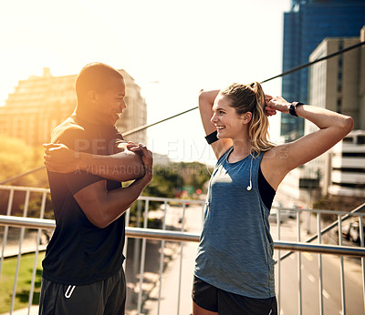 Buy stock photo Shot of two sporty young people warming up before a run