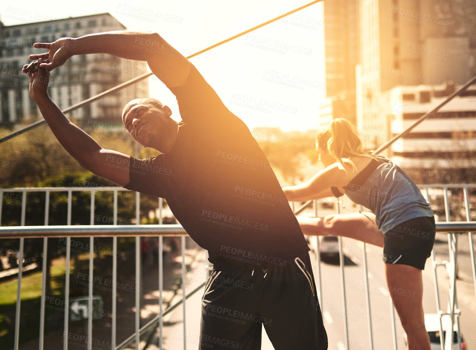 Buy stock photo Runner, man and woman with warm up in city for muscle, health and start training on metro bridge. People, partnership and stretching together for exercise, fitness and workout for wellness at sunset