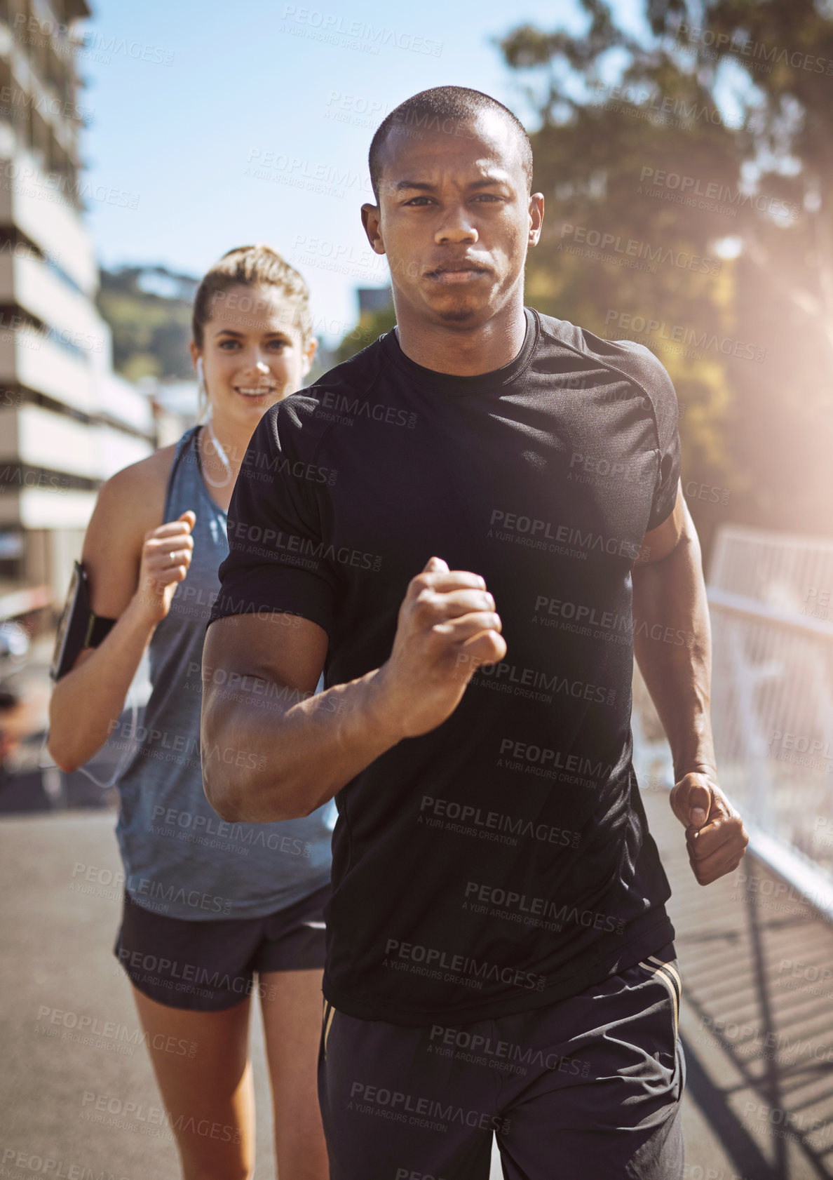 Buy stock photo Shot of two young people talking a run in the city