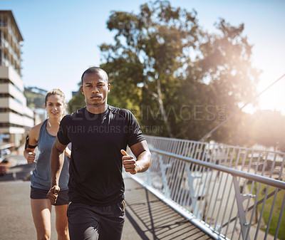 Buy stock photo Shot of two young people talking a run in the city
