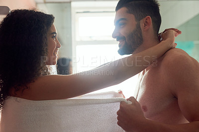 Buy stock photo Shot of a handsome young man flirting with his girlfriend after her shower